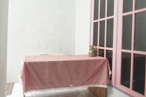 a pink table with a plant on it next to a window at Hotel O Karunia Kost & PenginapanNearSiring Marabahan (Ulek Barito) in Sungaisalai