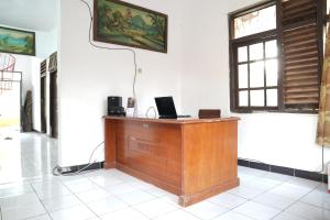 een houten bureau in een kamer met een raam bij SPOT ON 93655 Home Stay Syariah Habibie in Sukabumi