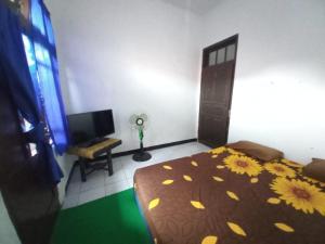 een slaapkamer met een bed met bloemen erop bij SPOT ON 93655 Home Stay Syariah Habibie in Sukabumi