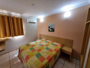 a bedroom with a bed with a colorful blanket at diRoma Fiori RM Hospedagem in Caldas Novas +34 photos