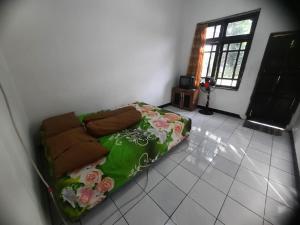 een woonkamer met een bank in de hoek van een kamer bij SPOT ON 93655 Home Stay Syariah Habibie in Sukabumi