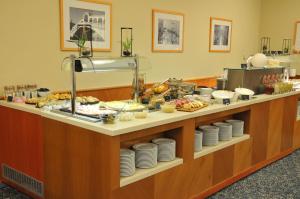 un buffet avec des assiettes et de la nourriture dans l'établissement Alexandria Spa & Wellness Hotel, à Luhačovice
