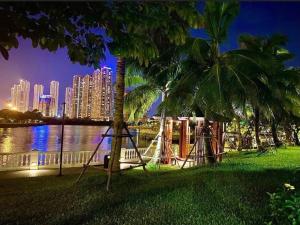 a swing and palm trees in a park with a city at Studio cao cấp Vinhomes Greenbay Mễ trì giá rẻ nhất Hà Nội in Hanoi