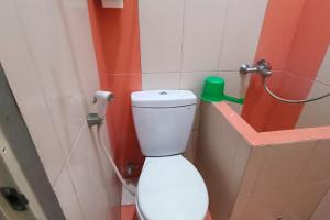 a bathroom with a white toilet in a room at OYO 93660 New Family Hotel Syariah in Magelang
