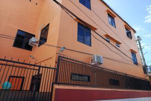 un edificio naranja con ventanas y una valla en OYO 93664 Homestay Purirano, en Lepoleop