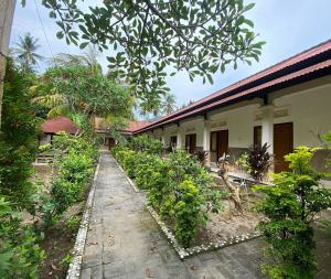 un jardin en face d'un bâtiment orné de plantes dans l'établissement OYO 93657 Puri Batu Bolong, à Senggigi