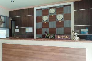 a reception counter with clocks on a wall at OYO 93665 Puri Homestay in Kendari