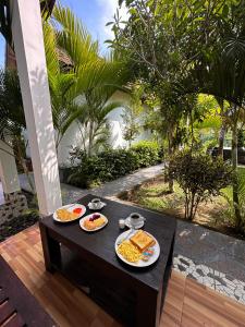 a table with three plates of food on it at Wahyu Masari Homestay in Nusa Penida