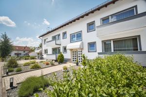 uma casa branca com um jardim em frente em Marias Inn - Bed & Breakfast em Garching bei München