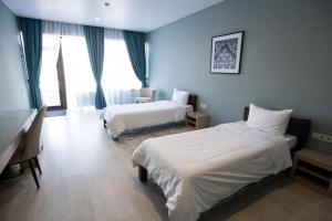 Pokój hotelowy z 2 łóżkami i biurkiem w obiekcie Arman Dala Resort w mieście Kaskelen
