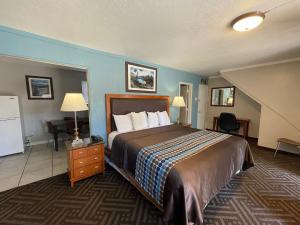 a hotel room with a large bed and a desk at Tahoe Hacienda Inn in South Lake Tahoe