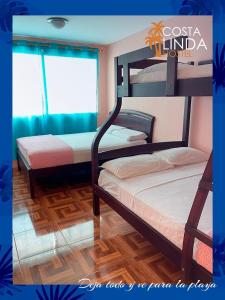 1 dormitorio con 2 literas y ventana en Hostal Costa Linda Salinas, en Salinas
