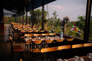 una fila de mesas y sillas en un restaurante en Khu Du lịch Nông trại Hải Đăng trên núi, en Gia Nghĩa