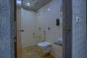 a bathroom with a toilet and a sink at Hotel Limra in Surat