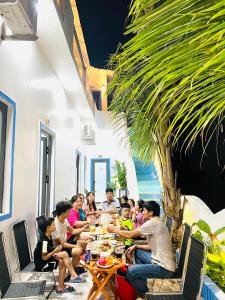 a group of people sitting at a table eating food at Homestay Vitamin SEA - View Biển Phú Quý in Cu Lao Thu