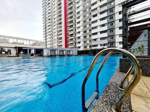 einem Pool mit blauem Wasser vor einem Gebäude in der Unterkunft 10 Guest Breezy 3 Room Koi Kinrara Suite, IOI Puchong, Bukit Jalil Pavilion, Bukit Jalil Stadium, Sunway Pyramid, Sunway Lagoon in Kampong Baharu Sungai Way