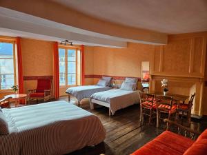 pokój hotelowy z 2 łóżkami, stołem i krzesłami w obiekcie LA GARDE DUCALE w mieście Moncontour