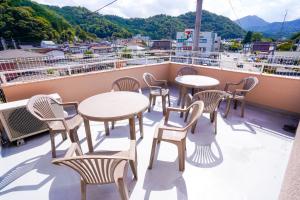 un balcón con mesas y sillas en un crucero en 【寿家】3F建 スカイビューテラス付き！新装開店　より道の湯すぐ横 en Tsuru 