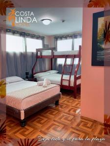 a bedroom with two bunk beds in a room at Hostal Costa Linda Salinas in Salinas