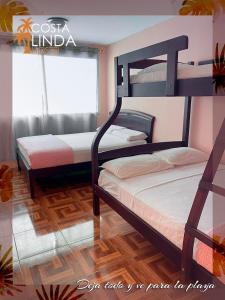 1 dormitorio con 2 literas y ventana en Hostal Costa Linda Salinas, en Salinas