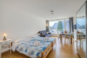 a bedroom with a bed and a living room at Il Piccolo Nido - Happy Rentals in Riva del Garda