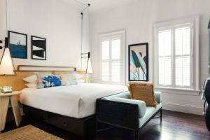 a bedroom with a large bed and a chair at Ridley House - Key West Historic Inns in Key West