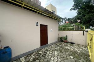 ein weißes Gebäude mit einer Tür und einer Terrasse in der Unterkunft SPOT ON 93624 Damai 3 Guest House Syariah in Bandung