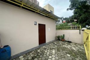 ein Gebäude mit einer braunen Tür und einer Terrasse in der Unterkunft SPOT ON 93624 Damai 3 Guest House Syariah in Bandung
