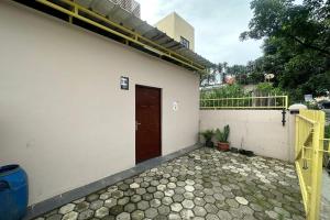 ein Gebäude mit einer braunen Tür und einer Terrasse in der Unterkunft SPOT ON 93624 Damai 3 Guest House Syariah in Bandung