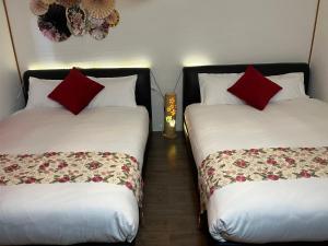 四日市市にあるYokkaichi City Guest Houseのベッド2台が隣同士に設置された部屋です。