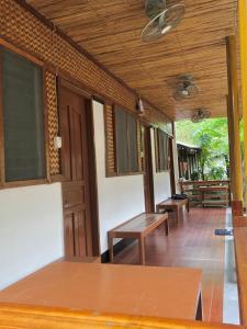 porche con 2 bancos y techo de madera en Hello Hostel en San Vicente
