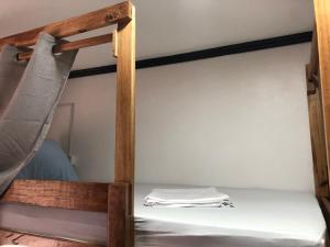 a wooden bunk bed with white sheets on it at Hello Hostel in San Vicente