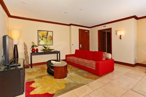 a living room with a red couch and a tv at Ko Olina Beach Villas B204 in Kapolei