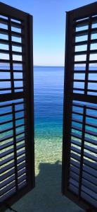 a view of the ocean through a window at Beach rooms Riviera - Žuta Kuća in Makarska