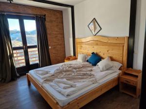 a bedroom with a large bed with a large window at Pensiunea Hanul Dorului in Drumu Carului