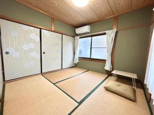 um quarto vazio com um quarto com uma janela em ゲストハウス 畔（hotori） 