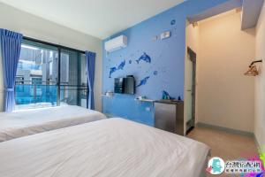 um quarto com 2 camas e uma parede azul em Baby Dolphin em Hengchun Old Town