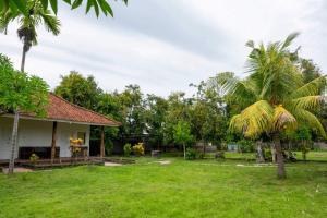 uma casa com um quintal com palmeiras em OYO 93604 Hepi Bungalow Lovina em Panji