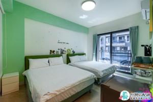 um quarto com duas camas e uma janela em Baby Dolphin em Hengchun South Gate
