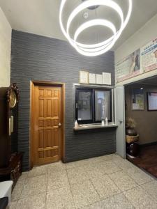een hal met een bruine deur en een kroonluchter bij Seongsan Motel in Seogwipo