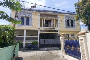 une maison avec un portail et une clôture bleue dans l'établissement OYO 93650 Pondok Baruga 777, à Kendari