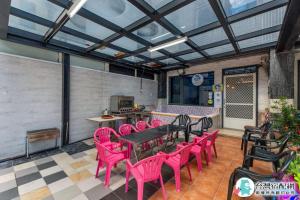 um pátio com cadeiras cor-de-rosa e uma mesa em Baby Dolphin em Hengchun South Gate