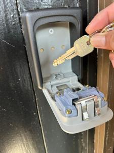 uma pessoa com uma chave num cofre em ゲストハウス 畔（hotori） 