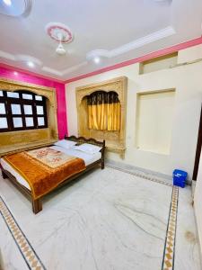 ジャイサルメールにあるHotel Golden Safariのピンクの壁のベッドルーム1室(ベッド1台付)
