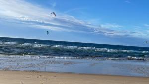 two people are flying kites on the beach at Villa with swimming pool 500 m from the beach in Moliets-et-Maa