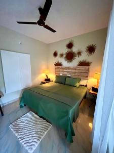 瓦卡拉的住宿－Point Break Varkala，一间卧室配有一张绿色的床和吊扇
