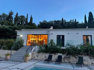 a house with a swimming pool in front of it at Villa Coco , un lieu convivial où se ressourcer. in Kalafatiónes