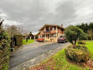 uma casa com dois carros estacionados em frente em Chalet con piscina climatizada. 