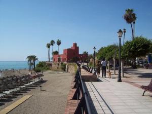 un trottoir avec bancs et palmiers sur la plage dans l'établissement Minerva 28, à Benalmádena