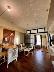 uma sala de estar com um sofá e uma mesa em Avida-Riala Tower 2, 3 New & Stylish Studio & 1BR Condo em Cebu